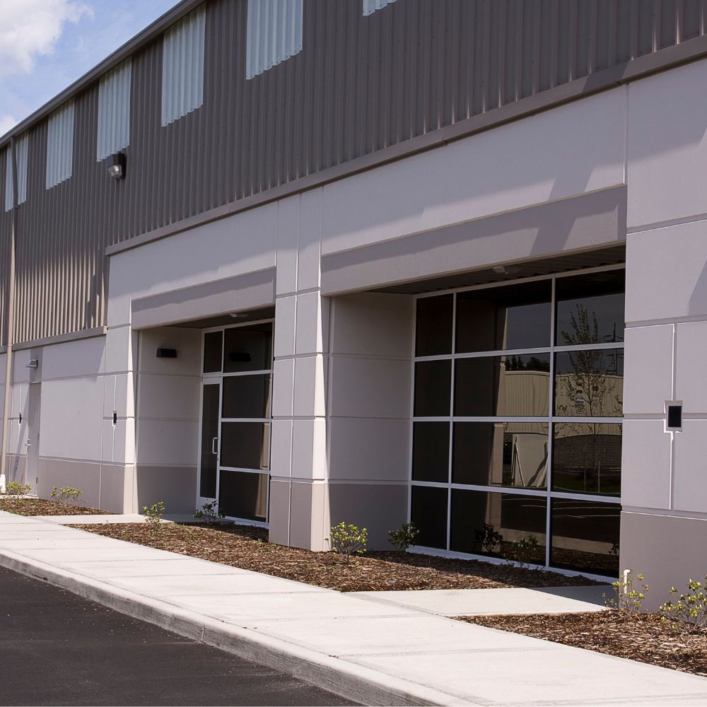 Warehouse strata units complex with individual blue roller doors and concrete frontage